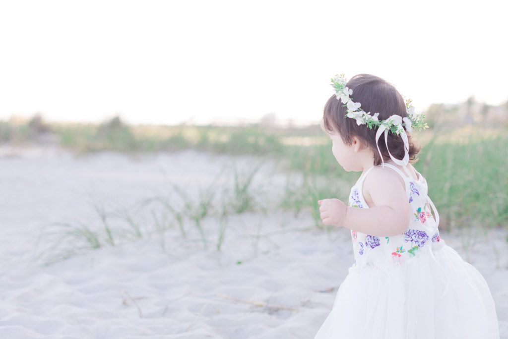 little girl on the beach wearing a floral crown
