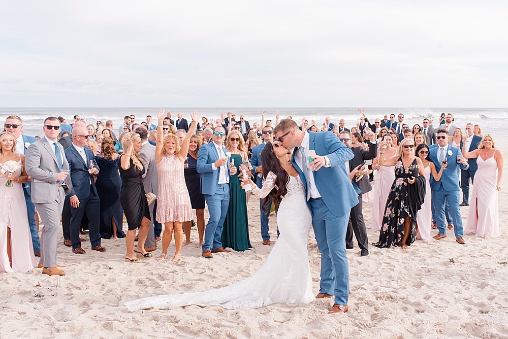 bride and groom with guests on the beach